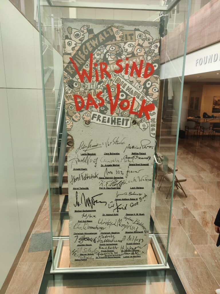 Teil der Berliner Mauer mit Gestaltung: "Wir sind das Volk" und Unterschriften von vielen Politikern und Diplomaten